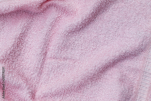 Slika na platnu Pink towel lying on a flat surface with soft texture and light shadows in a simp