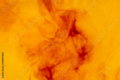 Fotografía Abstract red ink dissolving in warm yellow liquid background with soft flowing o