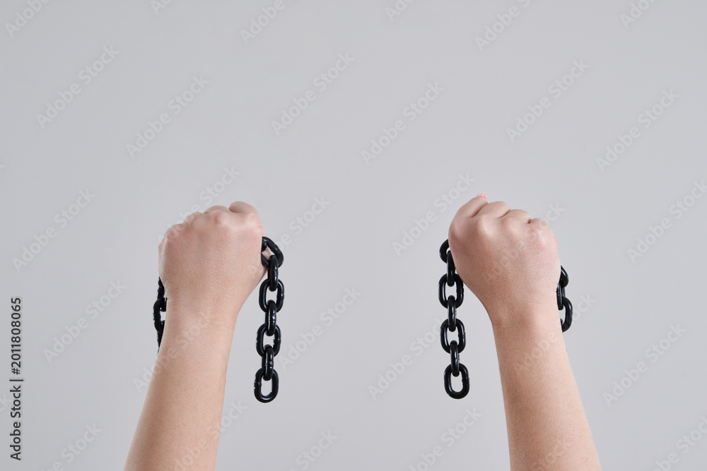 Ταπετσαρία Female hands holding a broken metal chain over grey background with copy space