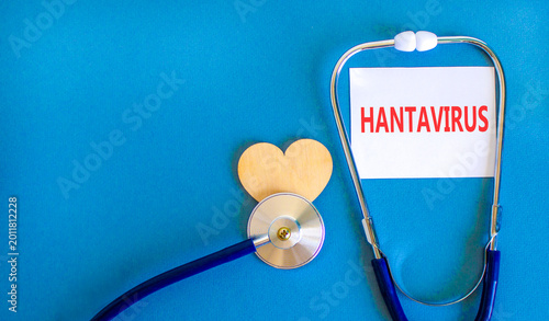 Hantavirus medical words symbol. Concept words Hantavirus on beautiful white card. Beautiful blue background. Beautiful wooden heart. Beautiful stethoscope. Medical Hantavirus concept. Copy space.