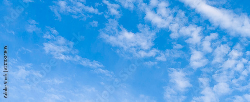 Bright blue sky with scattered white clouds on clear day.