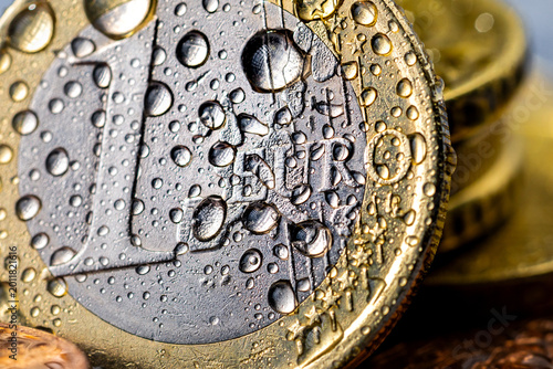 Close-up macro shot of one Euro coin with water droplets