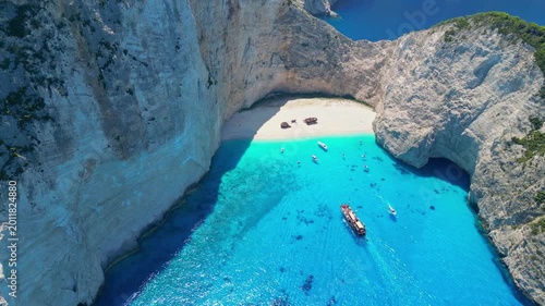 Spectacular view of the iconic Shipwreck beach in Navagio Bay, Zakynthos. Famous rusted boat on white sand surrounded by massive limestone cliffs and turquoise Ionian Sea water.