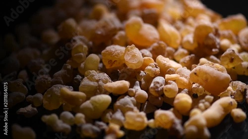 Olibanum Frankincense resin, Boswellia sacra background. Frankincense or olibanum aromatic resin for incense and perfumes, dark rotating backdrop, design, macro shot. 