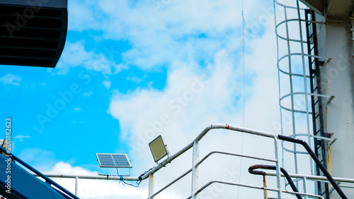 Bild auf Leinwand shot of a ship upper deck railing featuring a small solar panel and an LED floodlight