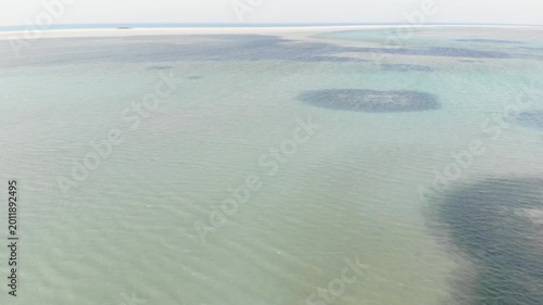 Panoramic aerial video of the calm and clear ocean surrounding Socotra, showcasing shallow reefs and pristine marine ecosystems