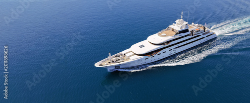 Aerial drone ultra wide panoramic photo with copy space of luxury yacht with wooden deck cruising near port Port Hercules in deep blue sea, Monaco, France