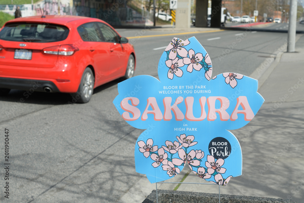 Fototapeta premium Bloor on the Park BIA novelty shaped welcome sign for Sakura or cherry blossom viewing at High Park, Toronto (looking north on Keele St, north of Bloor St W)