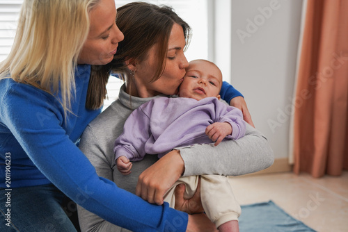 Female couple having tender moment with newborn baby son at home - Family, bonding, love and LGBT lifestyle concept