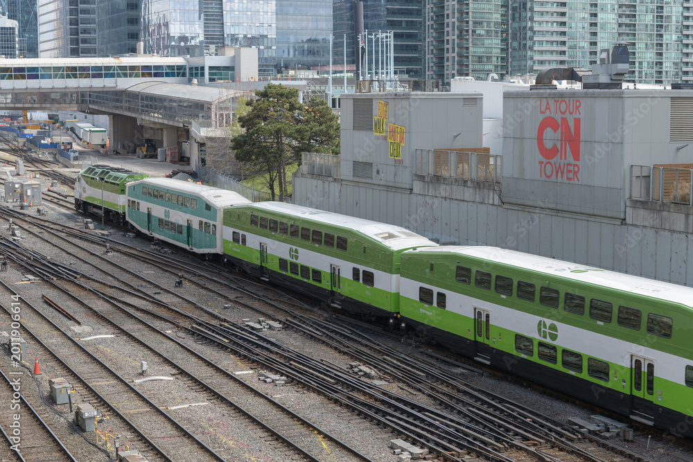 Fototapeta premium looking east over the Union Station Rail Corridor with Go Train and signs near CN Tower, Toronto
