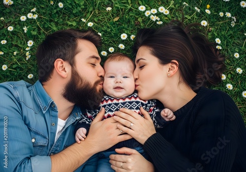 Happy father's day loving family portrait with baby in a meadow of daisies
