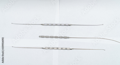 Cuadro en lienzo Three slender surgical probes with knurled grips on white background