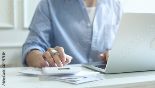 close up man hand press on calculator and check invoice letter from bank to check about debt and spending monthly for people lifestyle and inflation economic concept