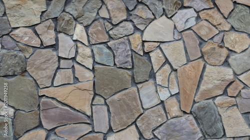 Decorative stone cladding for interior or exterior design using natural, large-size, lightly processed rock. Beautiful stone mosaic texture with randomly arranged cobblestones.