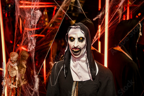 The atmospheric photography from the Halloween-themed event features a dramatic Halloween-inspired set, framed by spooky costumes, faux spider webs and mystical red lighting.