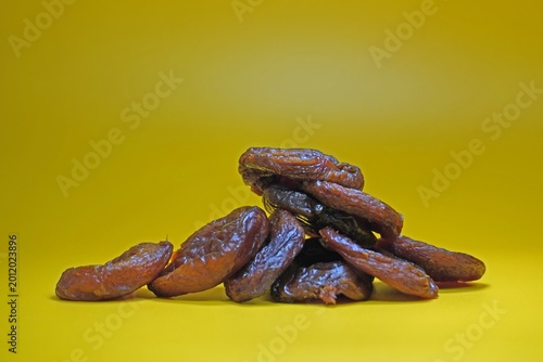 Принти на полотні Dried apricots are piled on a yellow background