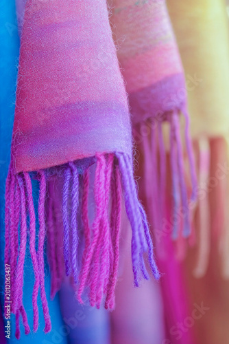 A collection of vibrant scarves displayed on a rack vertical frame