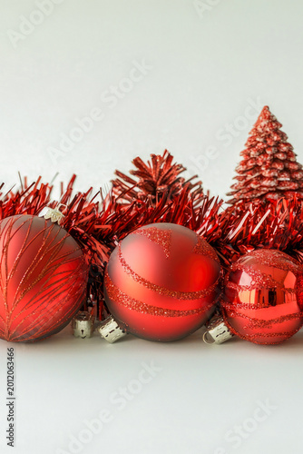A row of red and green Christmas ornaments hanging on a wall or tree vertical frame