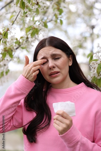 Fotografie Woman suffering from seasonal allergy in park on spring day