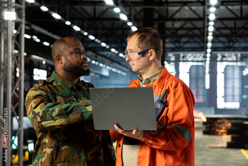 Картината върху платно Workers focused on wartime production through industrial facility, machinery and equipment support strategic defense operation