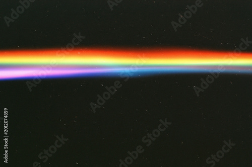 Vibrant rainbow light leak effect with vintage film grain and dust specks