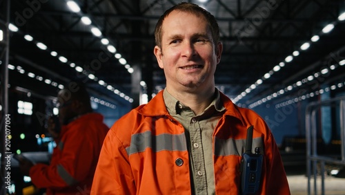 Photos Portrait of factory engineer monitors automation tools in a production plant, mechanical craftsmanship and manpower in industrial environment with heavy construction activity