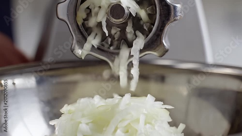 Closeup of a Meat Grinder Processing Fresh Onions for Cooking.