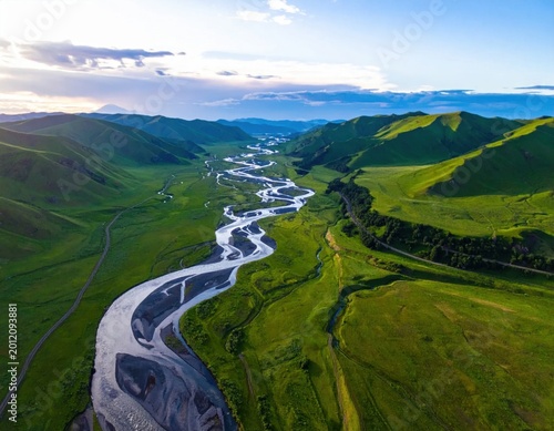 Aerial view of winding river snaking through vibrant green mountain valley at golden hour, peaceful nature landscape, environmental conservation, wilderness