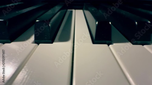 Cinematic close-up dolly shot moving along piano keys from a low angle
