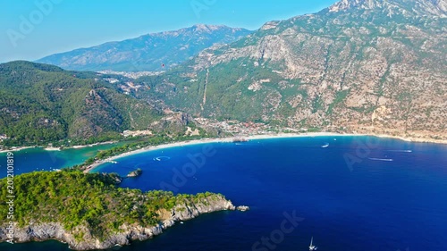 Drone view of Oludeniz Blue Lagoon, Turkey coast. Deep blue sea, green hills and sunny shoreline create a scenic vacation view.