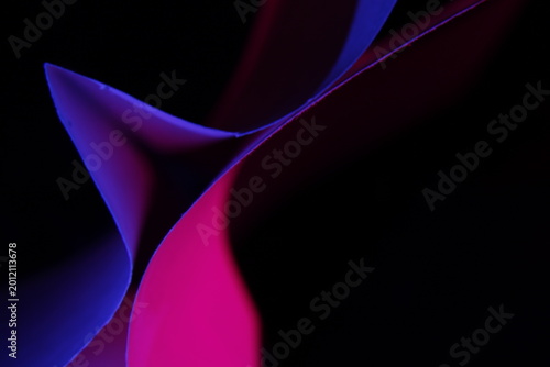 Canvastavla Composición abstracta de papeles coloridos con formas curvas y triangulares iluminadas con luces neón sobre fondo negro