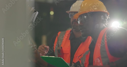 Technicians inspecting auto parts at liquid-filled station in auto parts factory