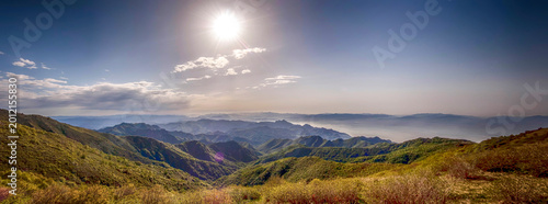 Foto Sunny day over mountainous landscape with green hills and clear sky