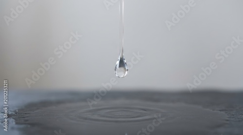 A single drop of water falling onto a reflective surface.