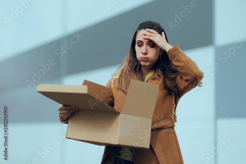 Unhappy Woman Looking Inside Open Delivery box Feeling Disappointed. Stressed female buyer reacting to the content from her recent online order
