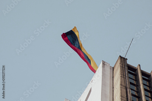 Foto Colombia flag waving in a blue cloudy sky