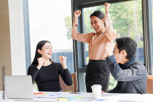 A group of multi-ethnic young professionals, aged 20-30, working together around a laptop in a bright office with large windows. The images show brainstorming, teamwork, celebration, and success in a 