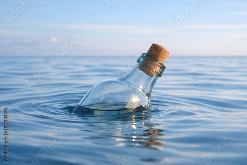 Message in bottle floating on calm blue sea with cork in ocean water