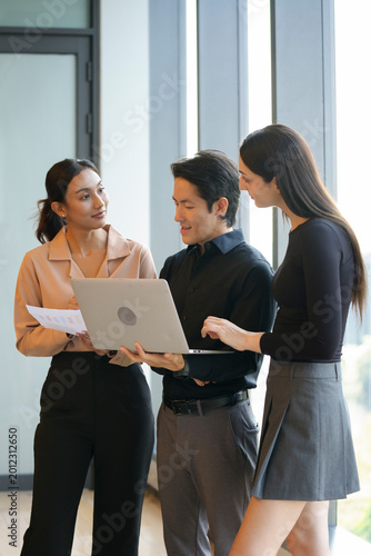 A group of multi-ethnic young professionals, aged 20-30, working together around a laptop in a bright office with large windows. The images show brainstorming, teamwork, celebration, and success in a 