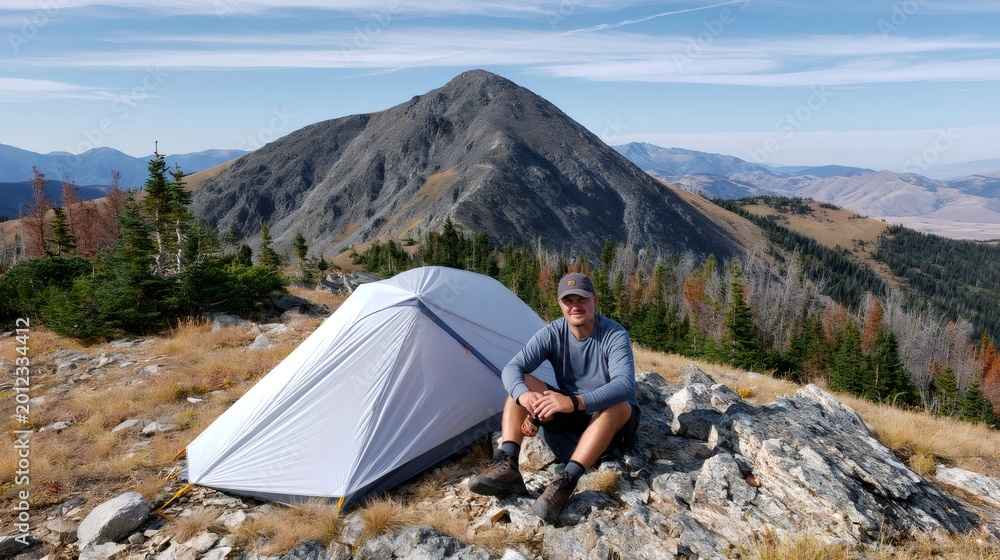 Fototapeta premium Man camping on mountain ridge with tent