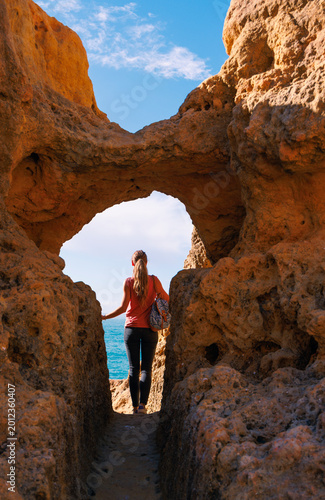 adventurous woman discovering a secret coastal passage in algar seco