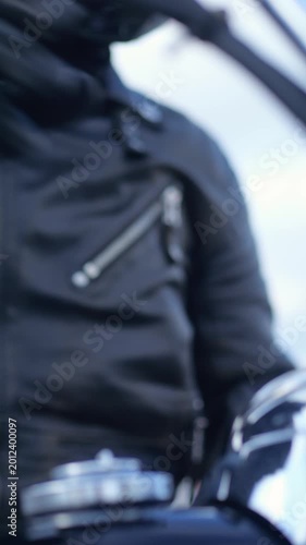 Biker putting on black leather riding gloves