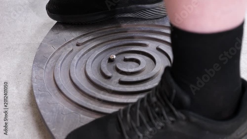 Person balancing on labyrinth balance board