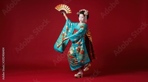 Beautiful geisha dancing with folding fan on red background