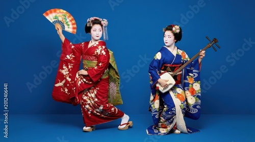 Geisha playing shamisen instrument with traditional dancer