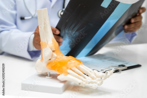 Photos Doctor examining foot ankle  joint bone radiography xray film.