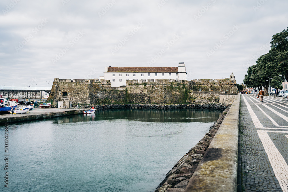 Fototapeta premium Historic seaside fortress and promenade under cloudy sky