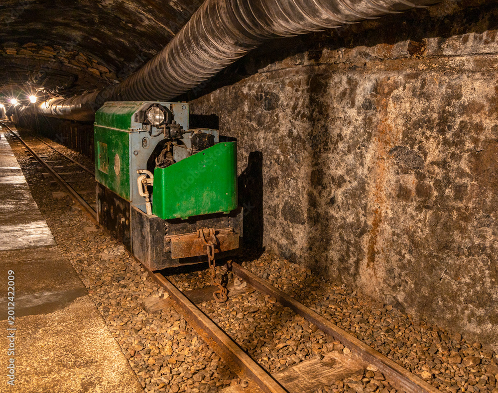 Fototapeta premium Abandoned mine tunnel with rails and mining cart