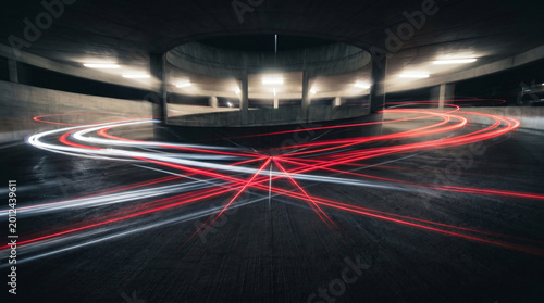 Long exposure of car light trails in a concrete parking garage