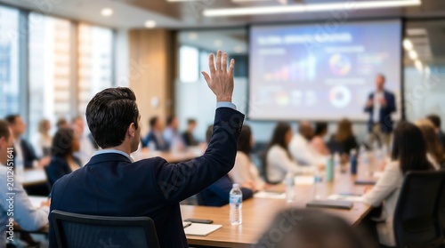 Diverse business team in a meeting room, with one man raising his hand to ask a question. Concept for strategic planning, collaborative environment and corporate workshop